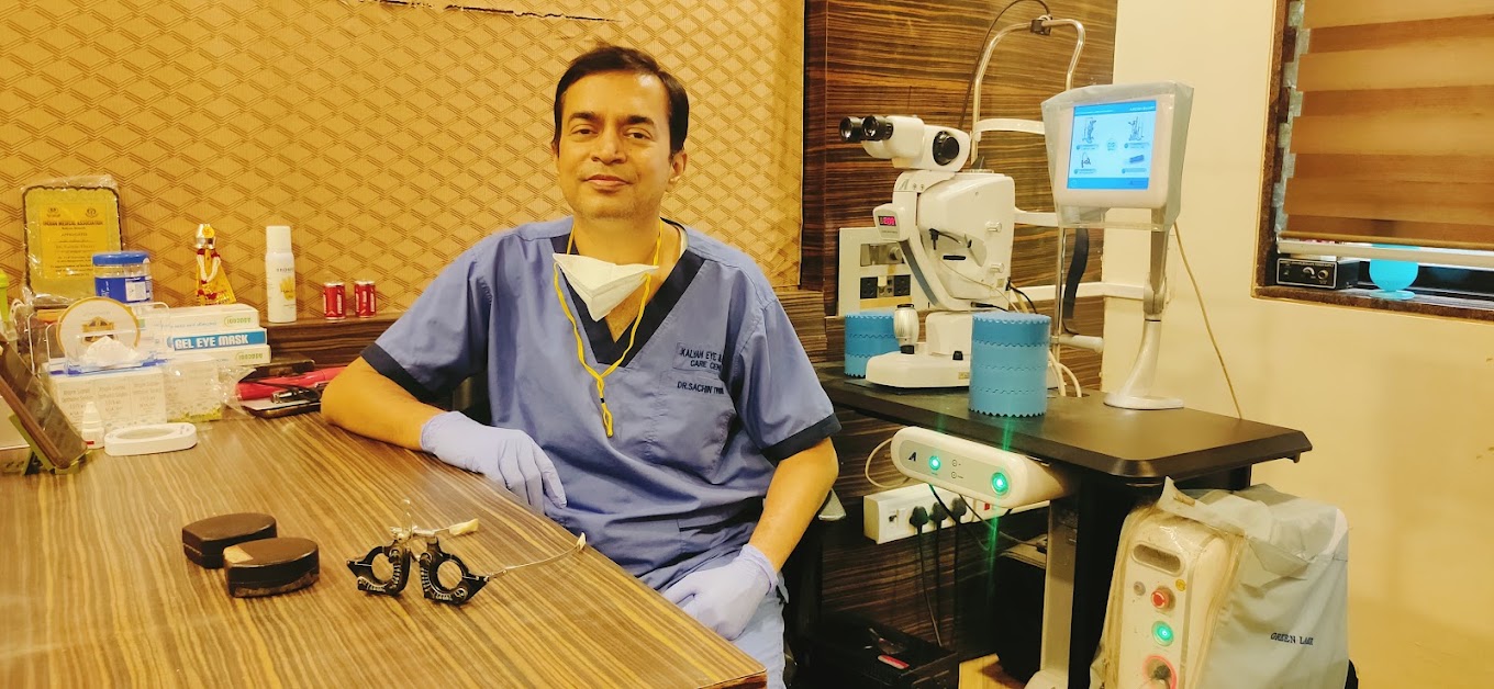Dr. Sachin Tiwari at his consultation desk with ophthalmic laser and slit-lamp equipment at Kalyan Eye & Retina Care Centre in Khadakpada, Kalyan West